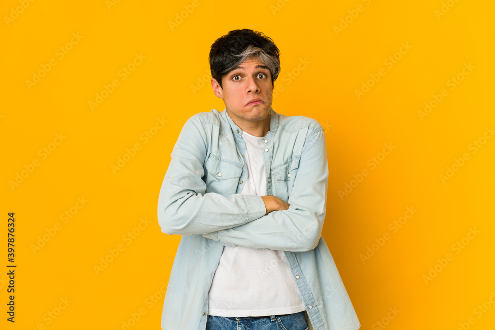 Young skinny hispanic man shrugs shoulders and open eyes confused. Young skinny hispanic man shrugs shoulders and open eyes confused.