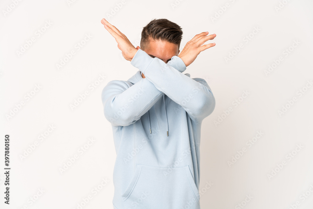 Young caucasian handsome man isolated keeping two arms crossed, denial concept. Young caucasian handsome man isolated keeping two arms crossed, denial concept.