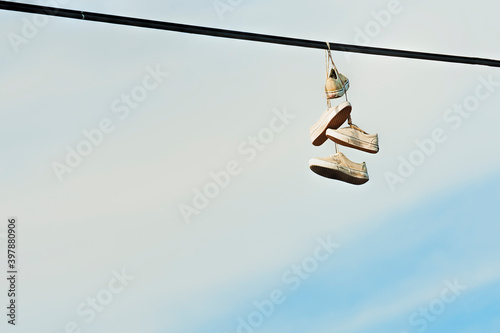Two pairs of shoes hanging from powerlines