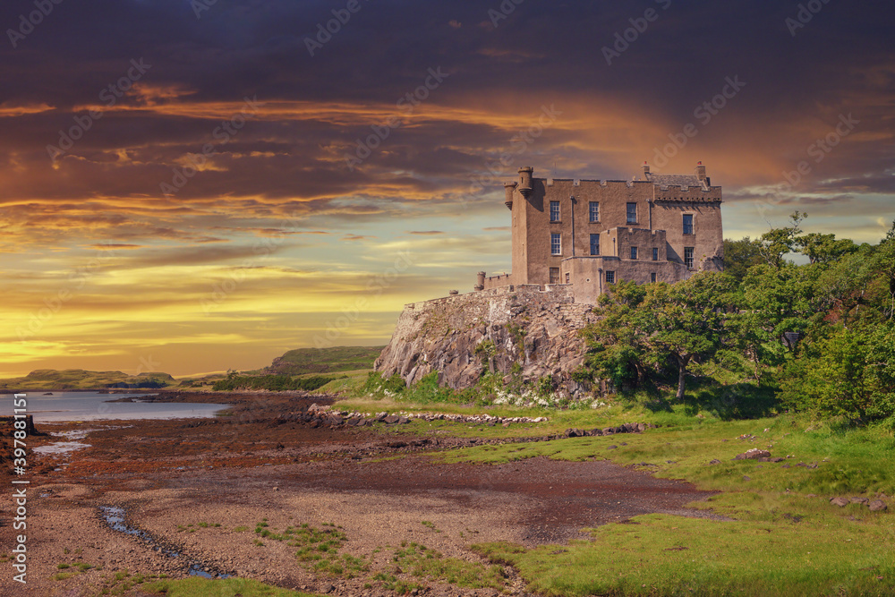 Dunvegan Castle on the Isle of Skye, Scottish Highlands at Loch of Dunvegan, in a dramatic sunset, Scotland