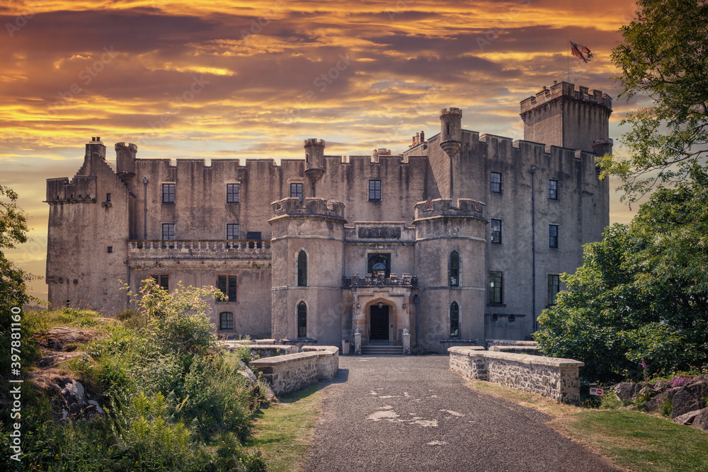 Front entrance of Dunvegan Castle on the Isle of Skye, Scottish Highlands at Loch of Dunvegan, in a dramatic sunset, Scotland