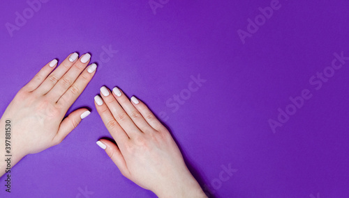 Female manicure on a bright background. Purple