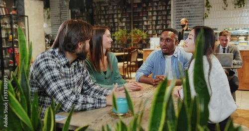 Wallpaper Mural Young attractive multi-national friends meeting at modern cafe communicating about their lifestyle laughing enjoying hangout party together. Coffee shop. Friendship. Torontodigital.ca