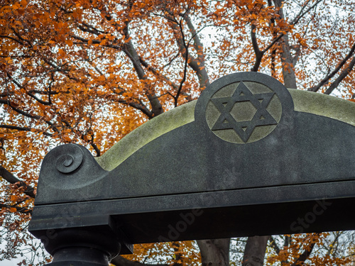 Old Historic Jewish Cemetery from 19th century in Wroclaw, Breslau, Poland during golden autumn, orange and yellow leaves, old graves with german and hebrew names - The museum of cemetery art