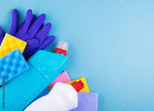 Cleaning products and tools on a blue background, with space for text