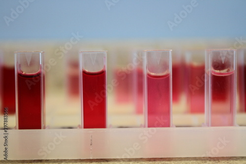 Cuvettes in Holders Containing Samples of Red Liquid in a Laboratory, ready for Testing in a Colorimeter. photo