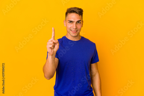 Young handsome caucasian man isolated showing number one with finger.