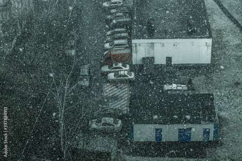 Cars in the yard during the snowfall in Moscow