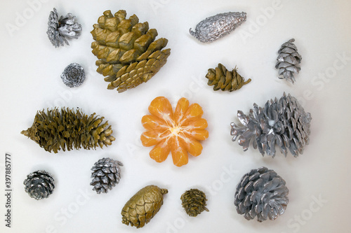 Slices of tangerine among cones painted in gold and silver.