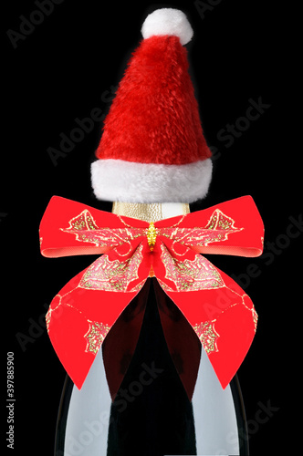 Champagne Bottle with Red Holiday Bow and Santa Hat on Black Background