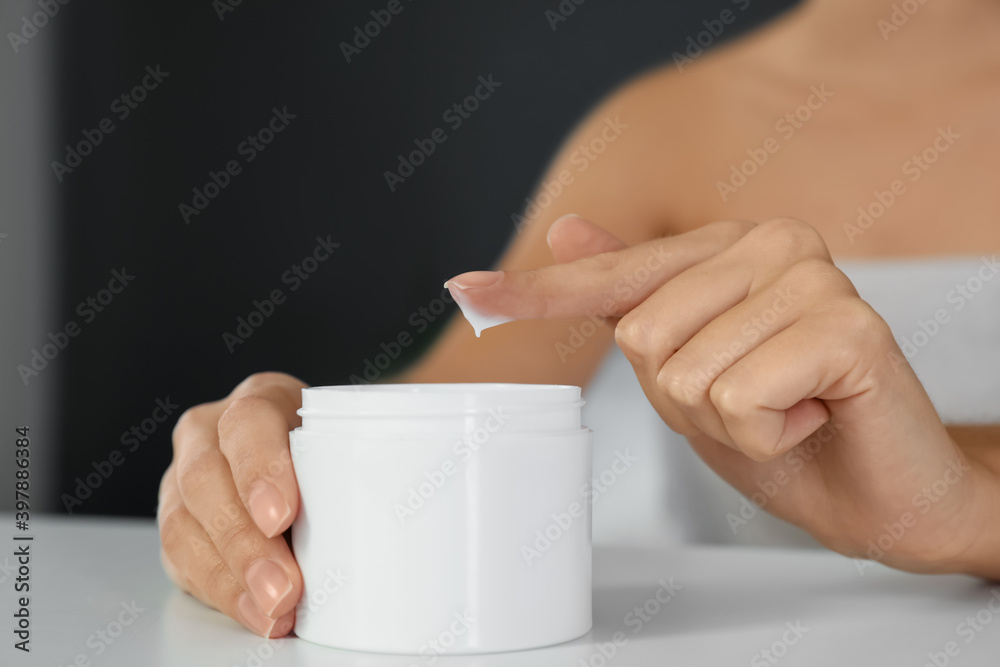 Woman with jar of moisturizing cream at white table, closeup Woman with jar of moisturizing cream at white table, closeup