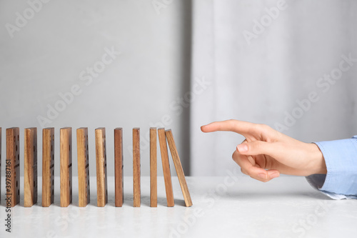 Woman with wooden dominoes at white table, closeup