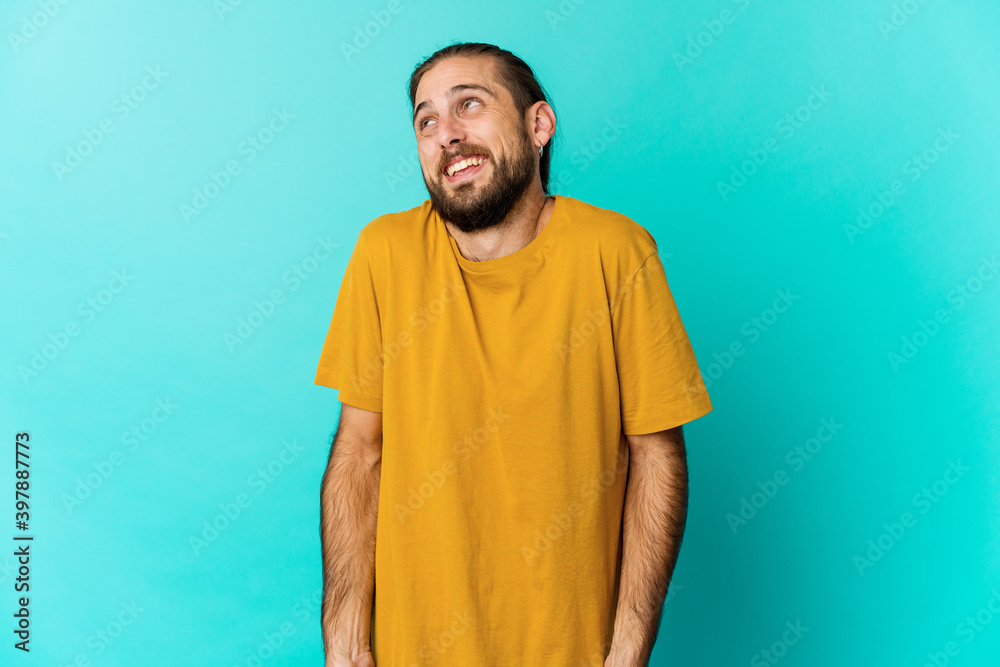 Young man with long hair look laughs and closes eyes, feels relaxed and happy. Young man with long hair look laughs and closes eyes, feels relaxed and happy.
