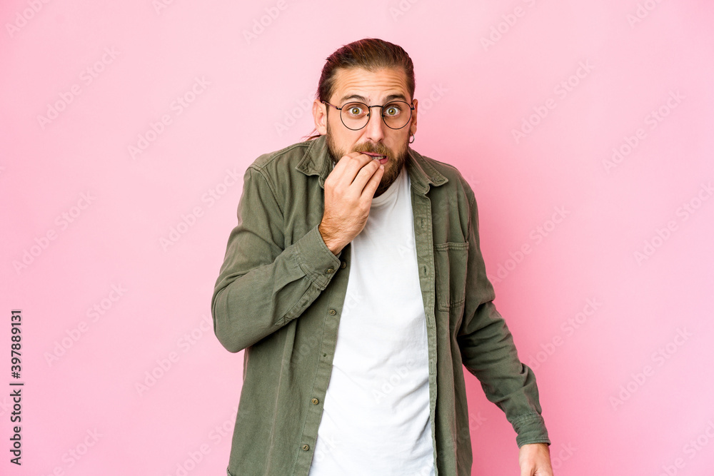 Young man with long hair look biting fingernails, nervous and very anxious. Young man with long hair look biting fingernails, nervous and very anxious.