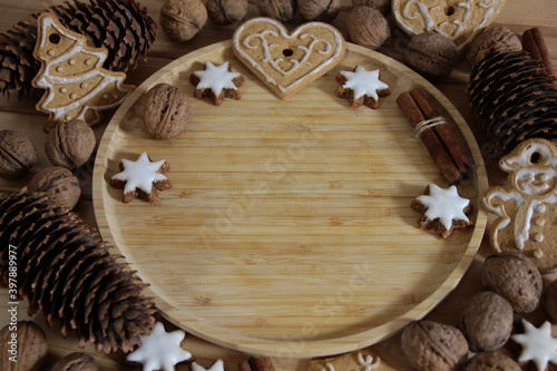 Christmas background with gingerbread, nuts, cinnamon sticks and pine cones