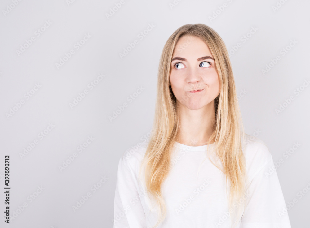 Photo of amazing blonde girl looking up empty space deep thinking isolated on grey background Photo of amazing blonde girl looking up empty space deep thinking isolated on grey background