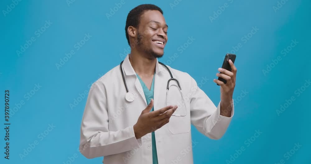 Friendly african american doctor talking to patient via video chat on smartphone, enjoying good result of recovery Friendly african american doctor talking to patient via video chat on smartphone, enjoying good result of recovery