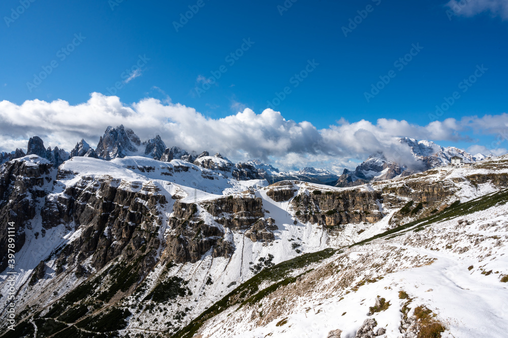 Mountain landscape with snow-capped peaks, the first snow on the peaks of the dolomites in autumn, the mountains turn white.