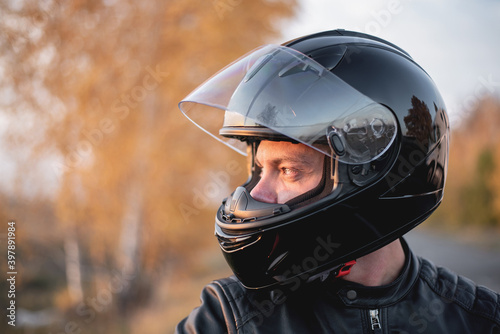 Biker in the helmet with open visor close up portrait. © Dmitriy