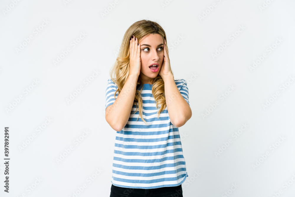 Young caucasian blonde woman covering ears with hands trying not to hear too loud sound. Young caucasian blonde woman covering ears with hands trying not to hear too loud sound.