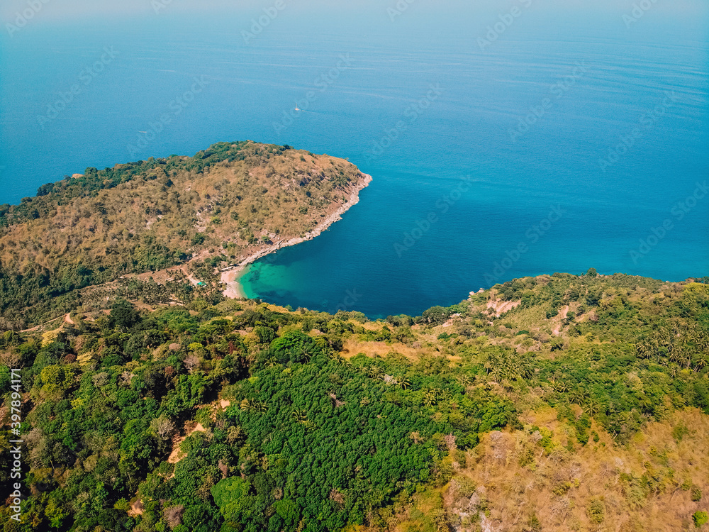 Bird's eye view of tropical isolated island with beautiful coast, blue aqua sea and many trees background