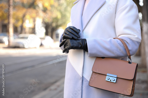 Woman with leather gloves and stylish bag on city street, closeup