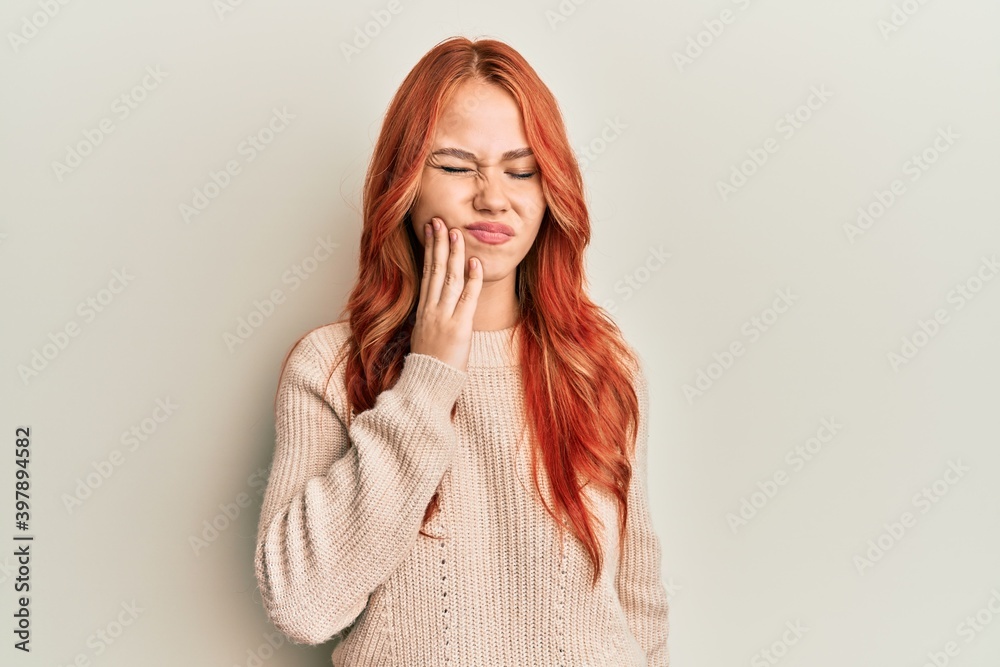 Young beautiful redhead woman wearing casual winter sweater touching mouth with hand with painful expression because of toothache or dental illness on teeth. dentist