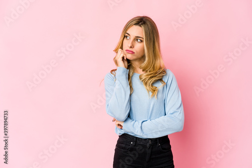 Young caucasian blonde woman saying a gossip, pointing to side reporting something. © Asier