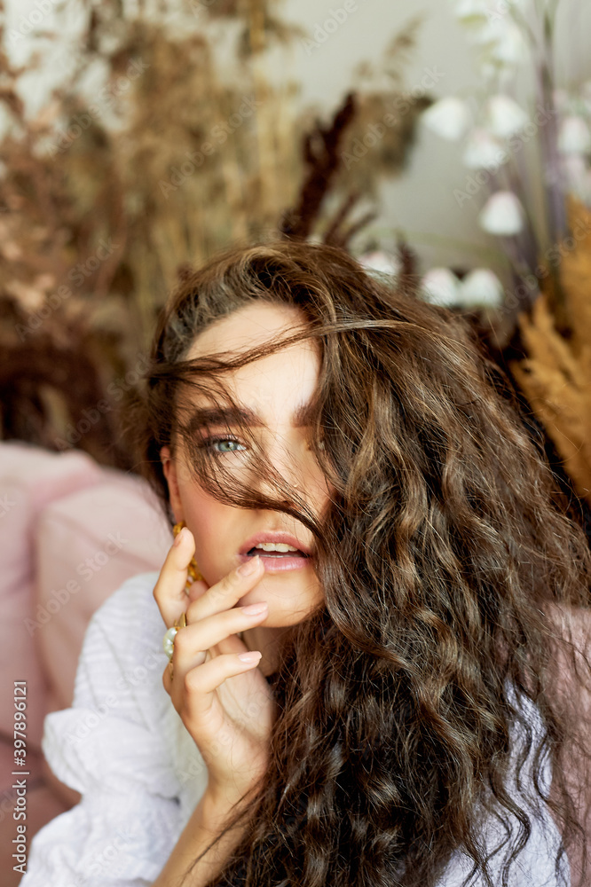 A girl of model appearance with long curly hair. An image of lightness and femininity A girl of model appearance with long curly hair. An image of lightness and femininity