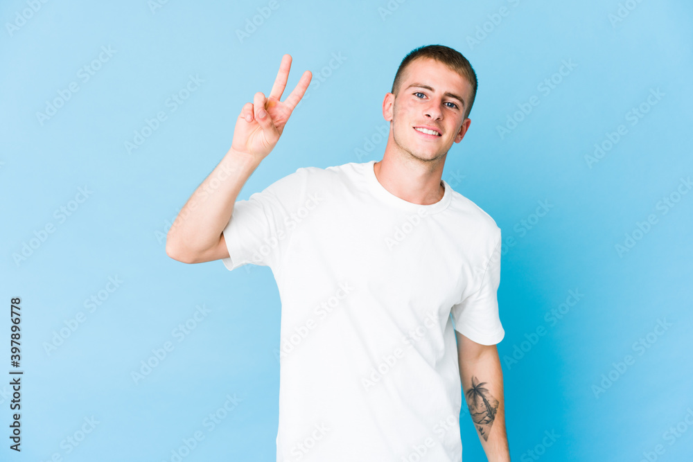 Young caucasian handsome man joyful and carefree showing a peace symbol with fingers. Young caucasian handsome man joyful and carefree showing a peace symbol with fingers.