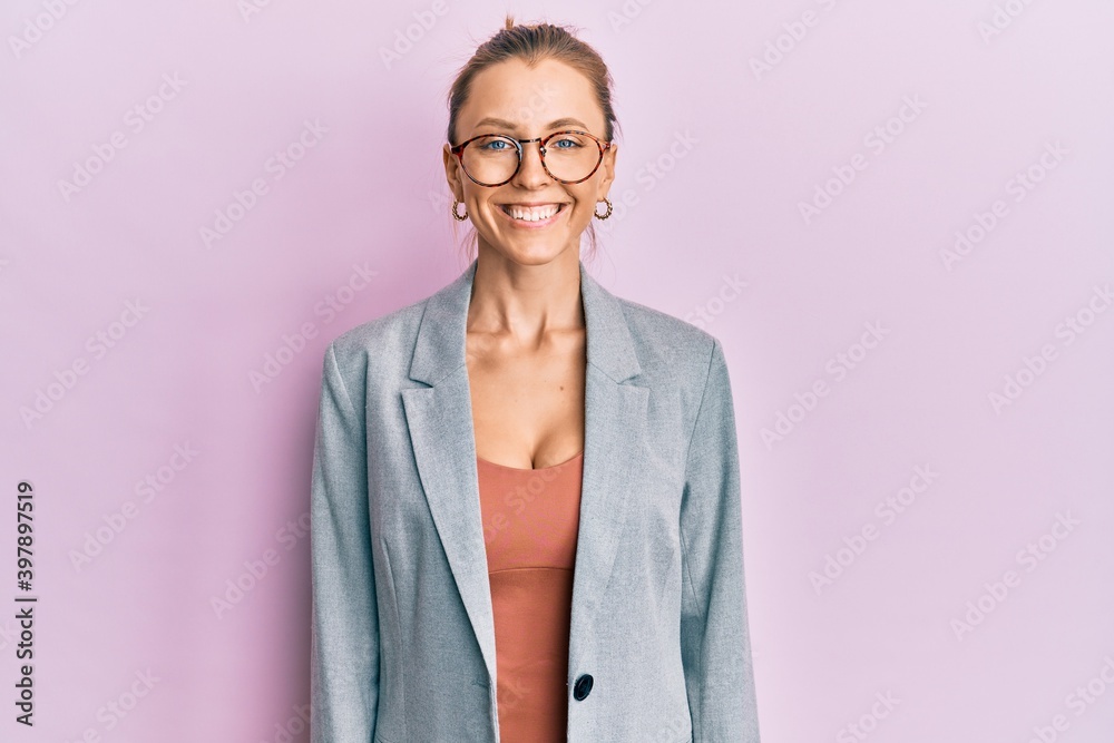 Beautiful caucasian woman wearing business jacket and glasses with a happy and cool smile on face. lucky person.