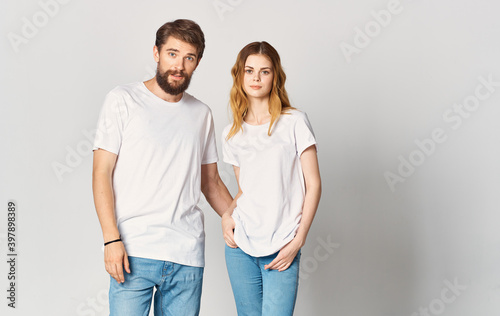 A man and a woman in jeans and a T-shirt are gesturing with their hands fun emotions Copy Space