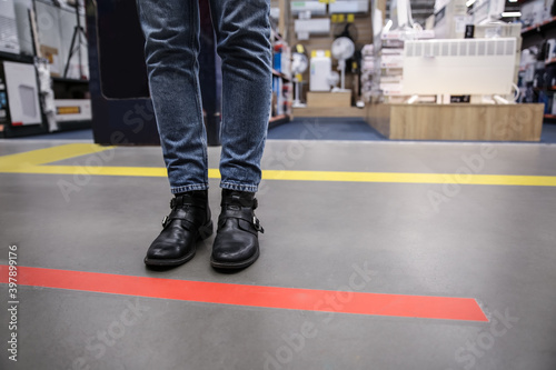 Slika na platnu Person standing behind taped floor marking indoors for social distance, closeup