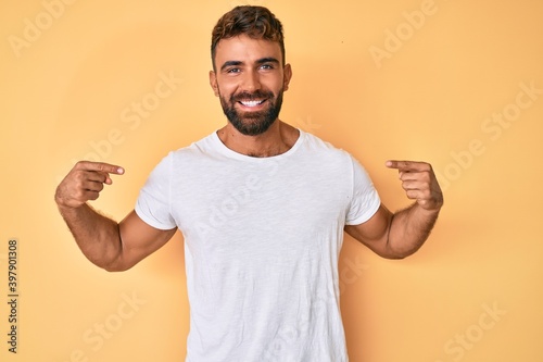 Young hispanic man wearing casual clothes looking confident with smile on face, pointing oneself with fingers proud and happy. © Krakenimages.com