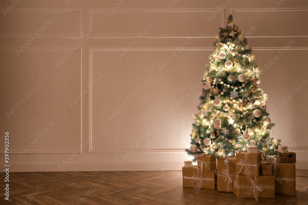 Beautiful decorated Christmas tree and gifts indoors. Space for text