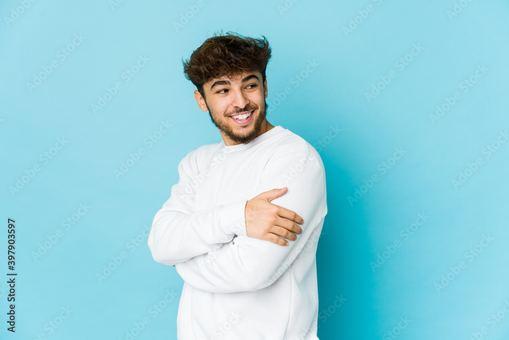 Young arab man on blue background laughing and having fun. Young arab man on blue background laughing and having fun.