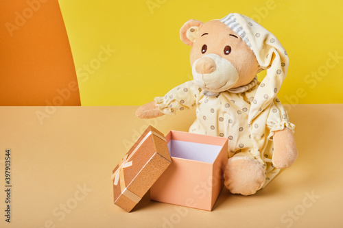 Cute Teddy Bear with gift box on biege background copy space © Natasha