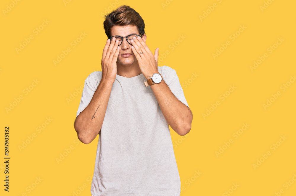 Handsome caucasian man wearing casual clothes and glasses rubbing eyes for fatigue and headache, sleepy and tired expression. vision problem Handsome caucasian man wearing casual clothes and glasses rubbing eyes for fatigue and headache, sleepy and tired expression. vision problem