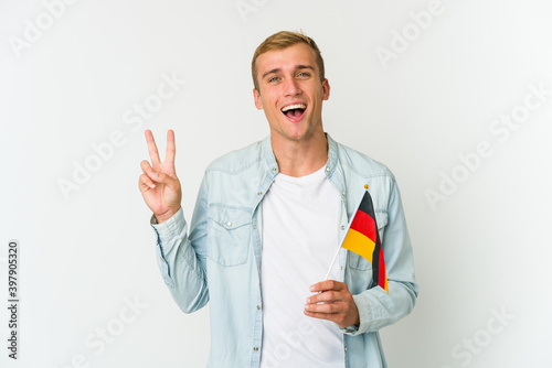 Young caucasian man holding a german flag isolated on white background