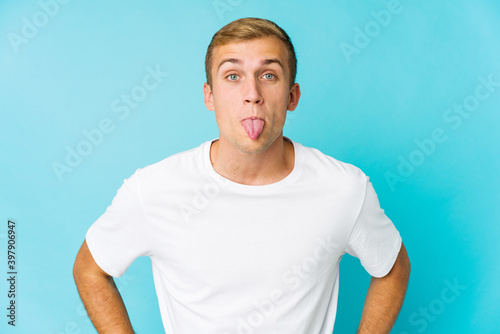 Young caucasian handsome man funny and friendly sticking out tongue.