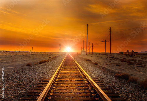 Straight railroad heading west towards the sunset somewhere in Utah