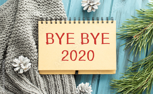 two green one black pencil with text 'Bye bye 2020' in the notebook on the wooden background