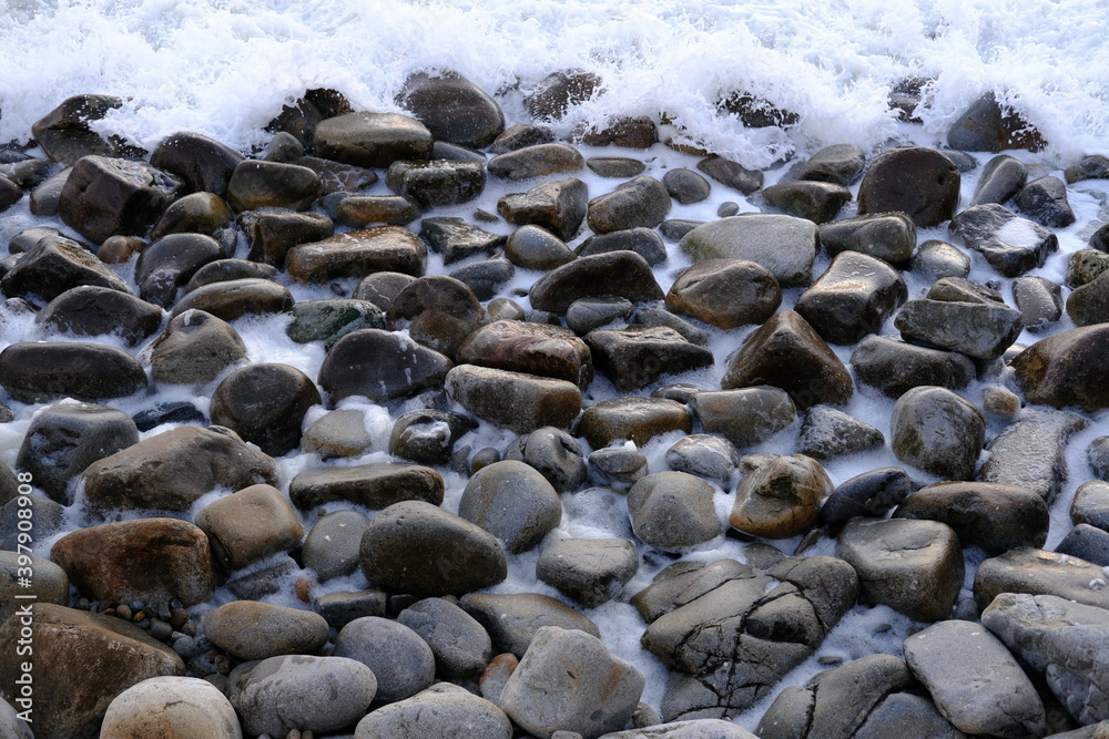 Some black stones on the shore. Some black stones on the shore.