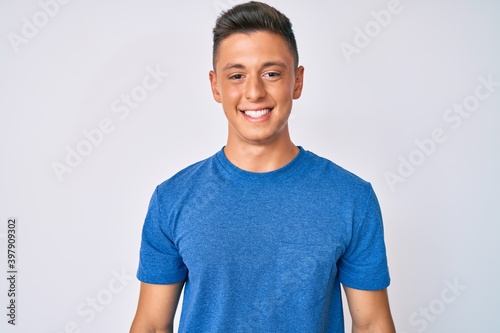 Young hispanic boy wearing casual clothes with a happy and cool smile on face. lucky person.