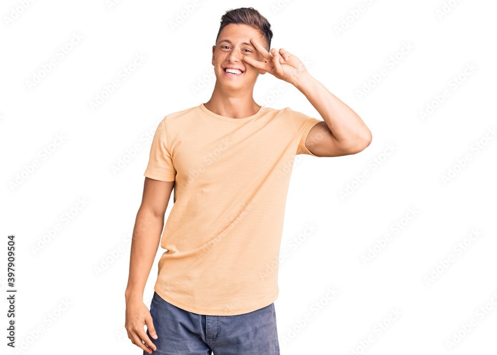 Young handsome man wearing casual clothes doing peace symbol with fingers over face, smiling cheerful showing victory Young handsome man wearing casual clothes doing peace symbol with fingers over face, smiling cheerful showing victory