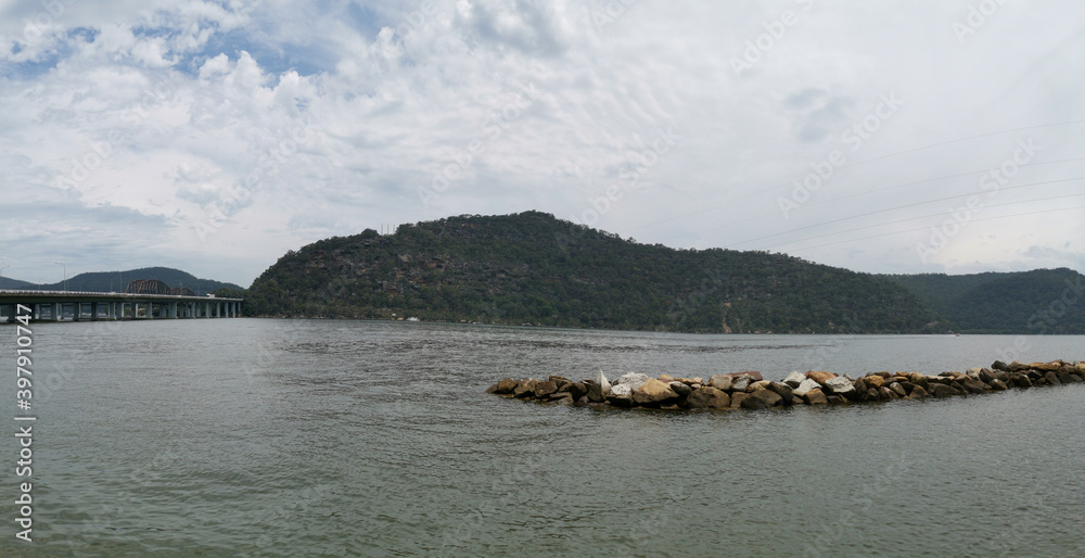 Beautiful panoramic view of a river on a cloudy day with tall mountains and trees in the background, Hawkesbury river, Deerubbun Reserve, Mooney Mooney, New South Wales, Australia
Beautiful panoramic view of a river on a cloudy day with tall mountains and trees in the background, Hawkesbury river, Deerubbun Reserve, Mooney Mooney, New South Wales, Australia