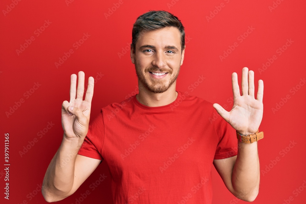 Handsome caucasian man wearing casual red tshirt showing and pointing up with fingers number eight while smiling confident and happy. Handsome caucasian man wearing casual red tshirt showing and pointing up with fingers number eight while smiling confident and happy.