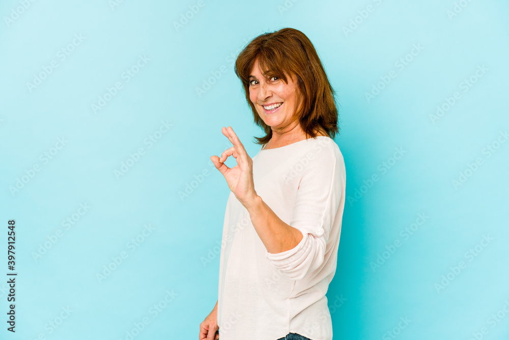 Senior caucasian woman isolated winks an eye and holds an okay gesture with hand. Senior caucasian woman isolated winks an eye and holds an okay gesture with hand.