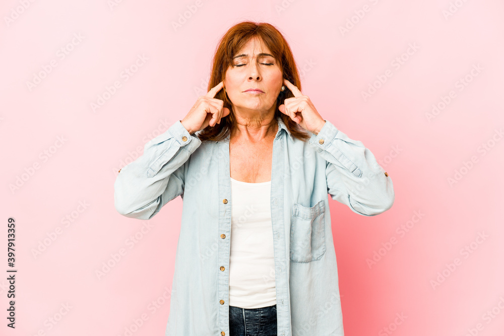 Senior caucasian woman isolated covering ears with fingers, stressed and desperate by a loudly ambient. Senior caucasian woman isolated covering ears with fingers, stressed and desperate by a loudly ambient.