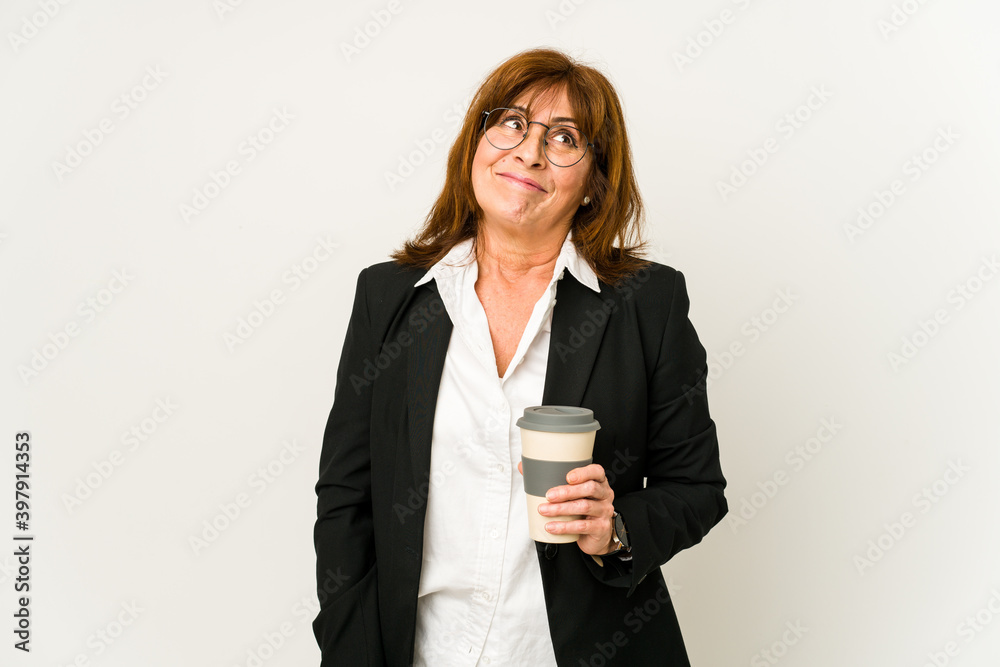 Middle aged business woman holding a takeaway coffee isolated dreaming of achieving goals and purposes Middle aged business woman holding a takeaway coffee isolated dreaming of achieving goals and purposes